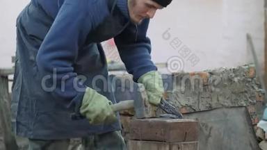 年轻的铁匠工作金属。 工匠，村里私人铁匠铺的高地人。 塑造金属坯体